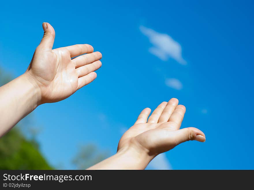 Two hands against the blue sky