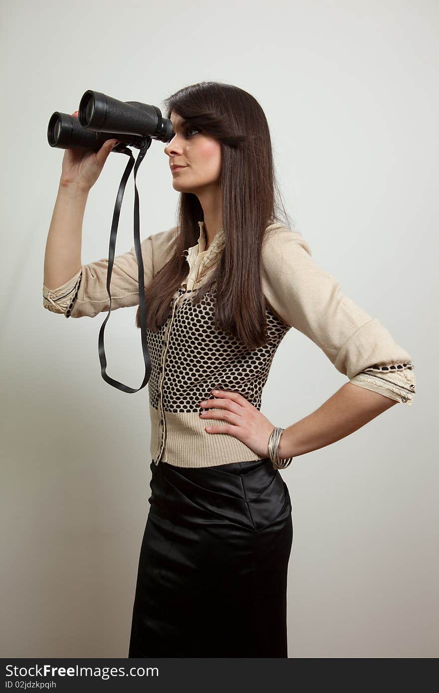 Young business woman holding and looking through binoculars. Isolated on white. Young business woman holding and looking through binoculars. Isolated on white