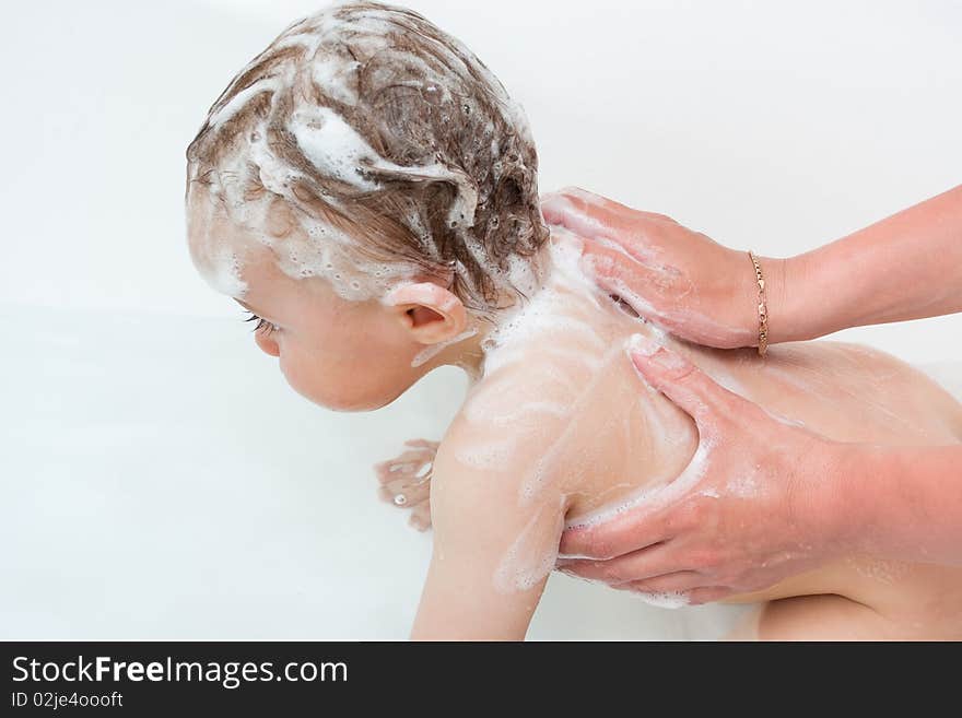 Mother washes the child with shampoo. Mother washes the child with shampoo