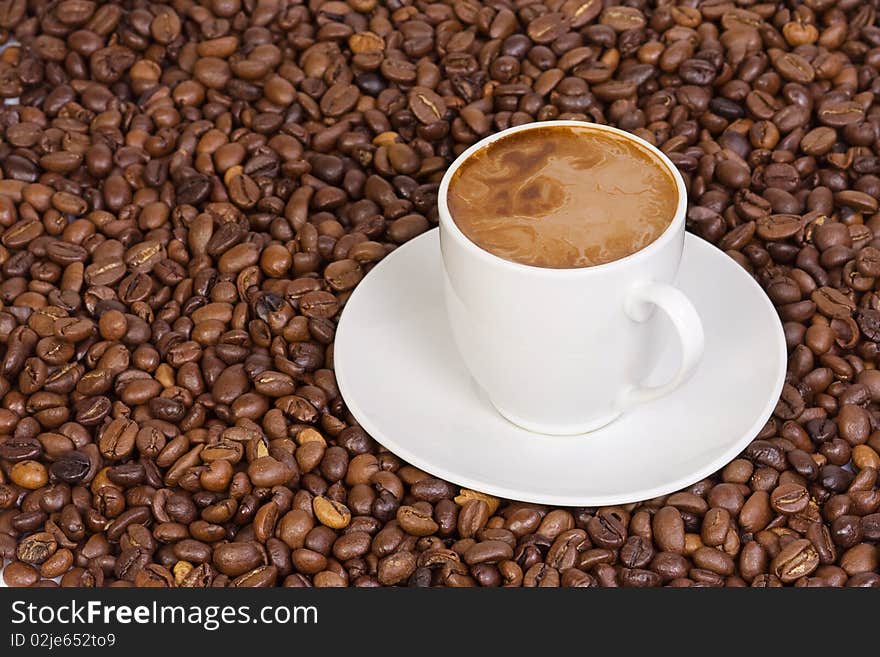 White ceramic cup at coffee beans