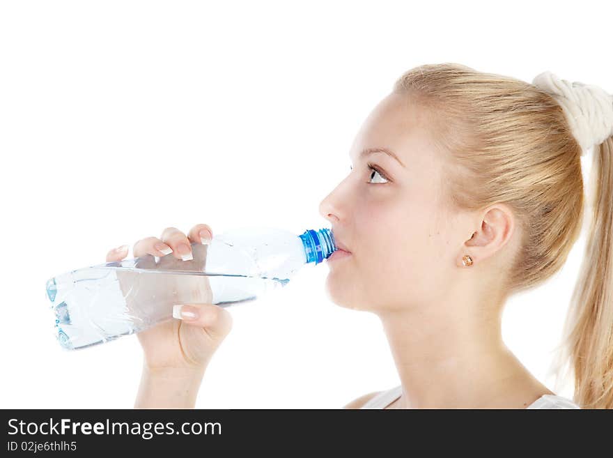 Young blonde is drinking water isolated on white. Focus on girl`s eyes.