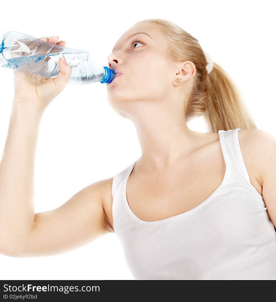 Young blonde is drinking water isolated on white. Focus on hand with bottle.