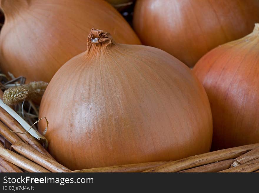 Brown onions on a bed of hay in a basket. Brown onions on a bed of hay in a basket