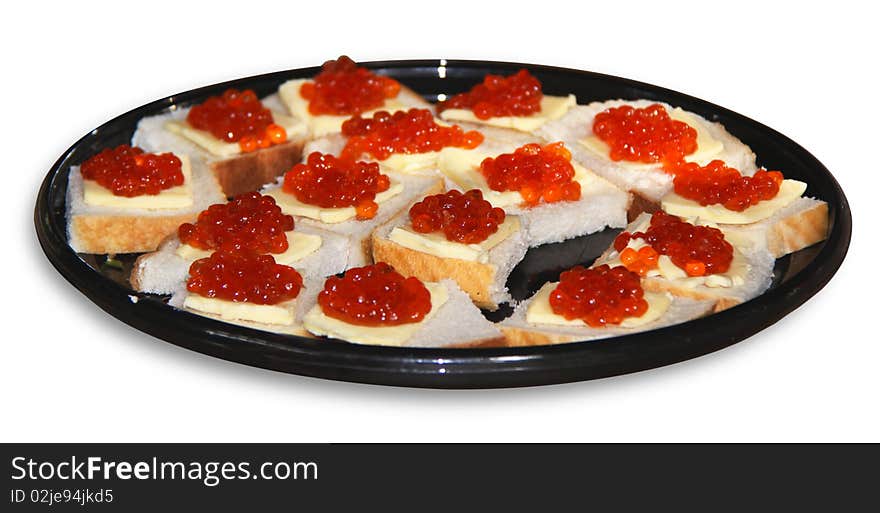 Bread and butter with red caviar on black plate isolated over white