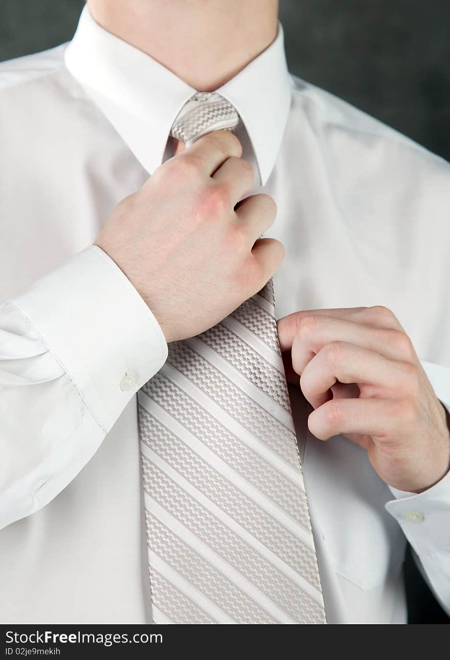 Businessman is adjusting his tie