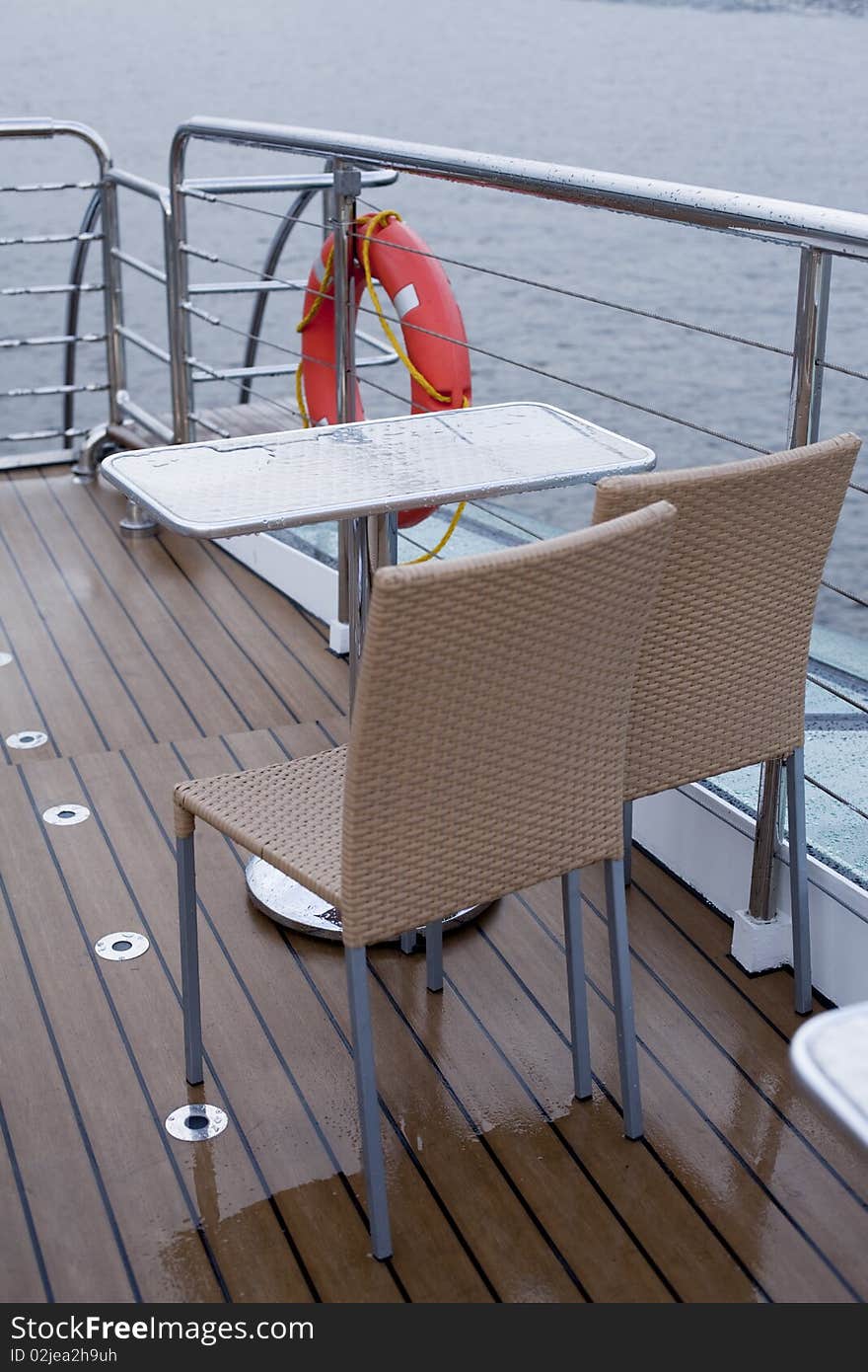 Table and two chairs on the deck of a cruise ship. Table and two chairs on the deck of a cruise ship