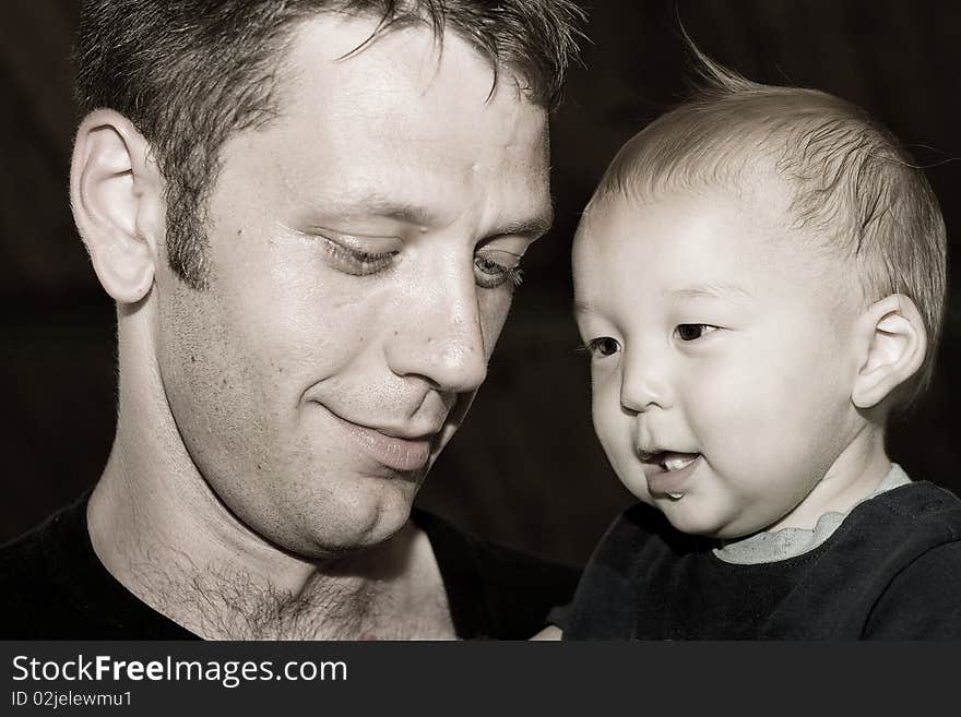 Multiracial Asian American child with his proud dad in sepia tone. You can just see the love between them. Multiracial Asian American child with his proud dad in sepia tone. You can just see the love between them.