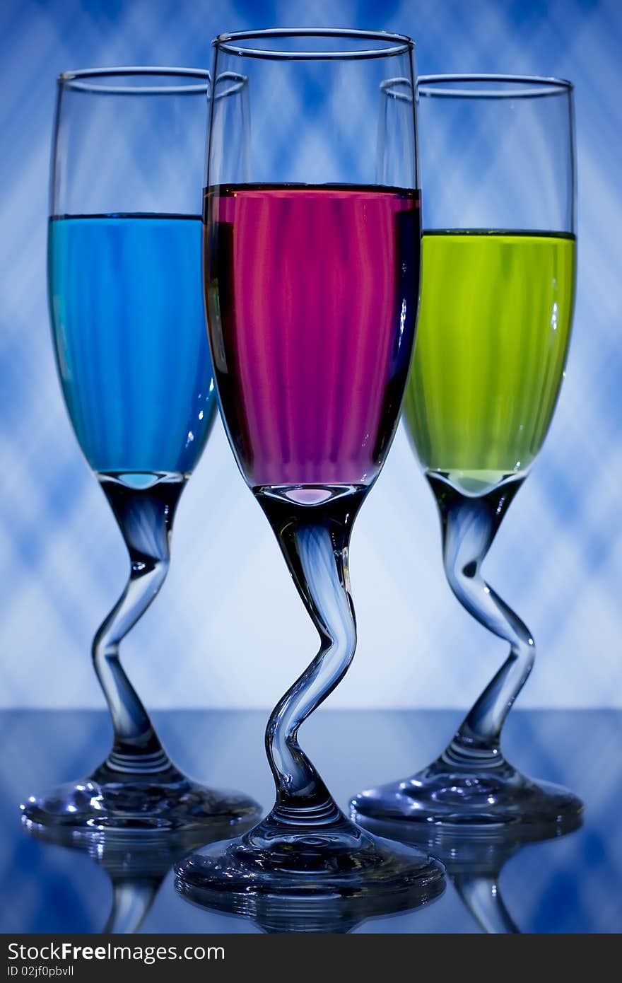 Blue, pink, and green, liqueur glasses on blue and white background. Blue, pink, and green, liqueur glasses on blue and white background