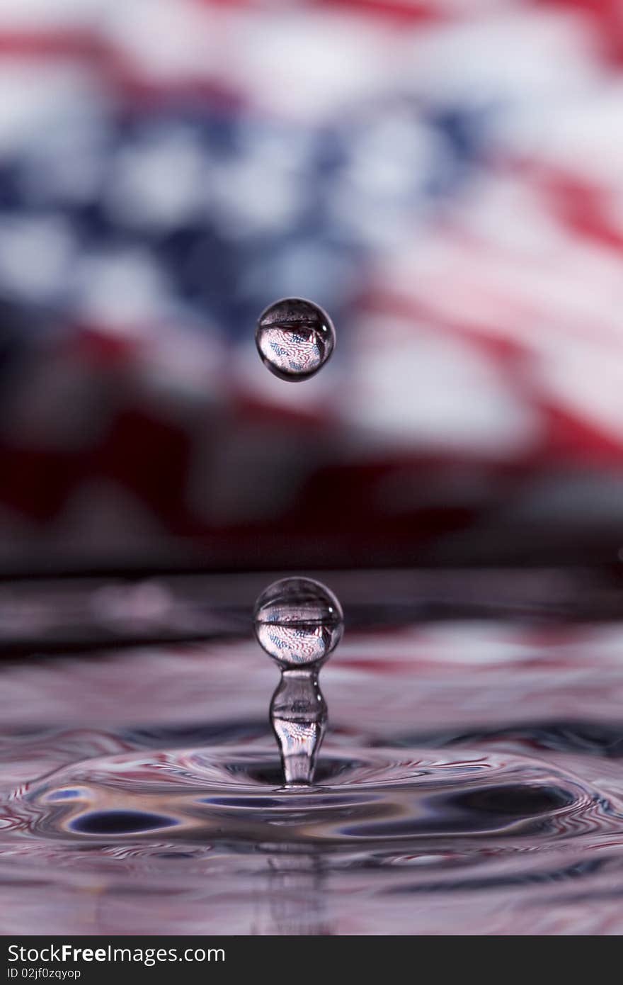 Beautiful waterdrop splashing with USA flag blurred in background. Beautiful waterdrop splashing with USA flag blurred in background