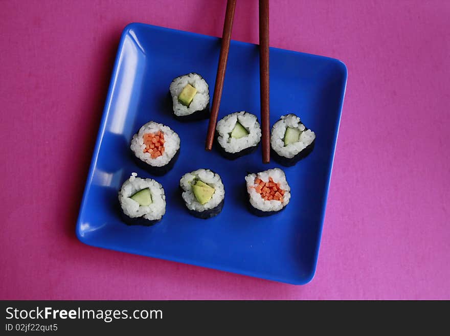 Vegetable sushi on blue plate with chopsticks