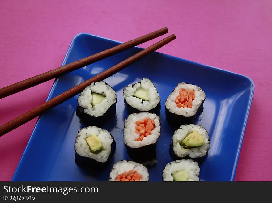 Vegetable sushi on blue plate with chopsticks