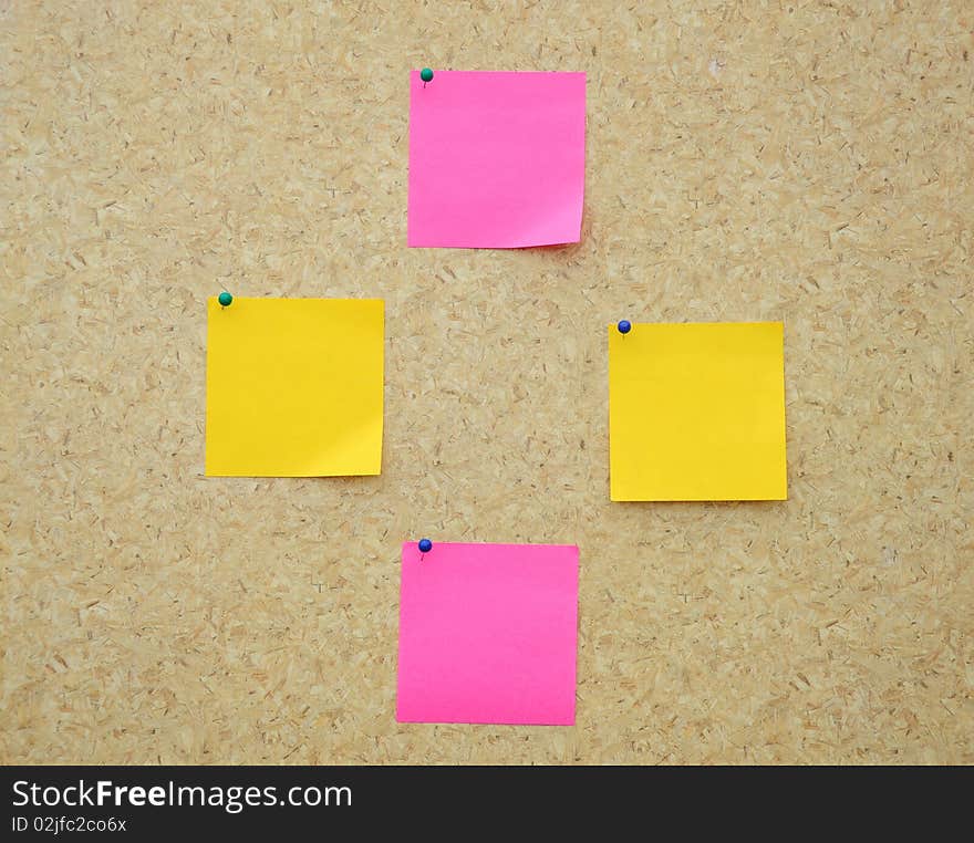 Four blank sticky notes on notice board