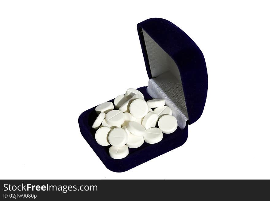 Heap of white tablets in a dark blue box on a white background. Heap of white tablets in a dark blue box on a white background