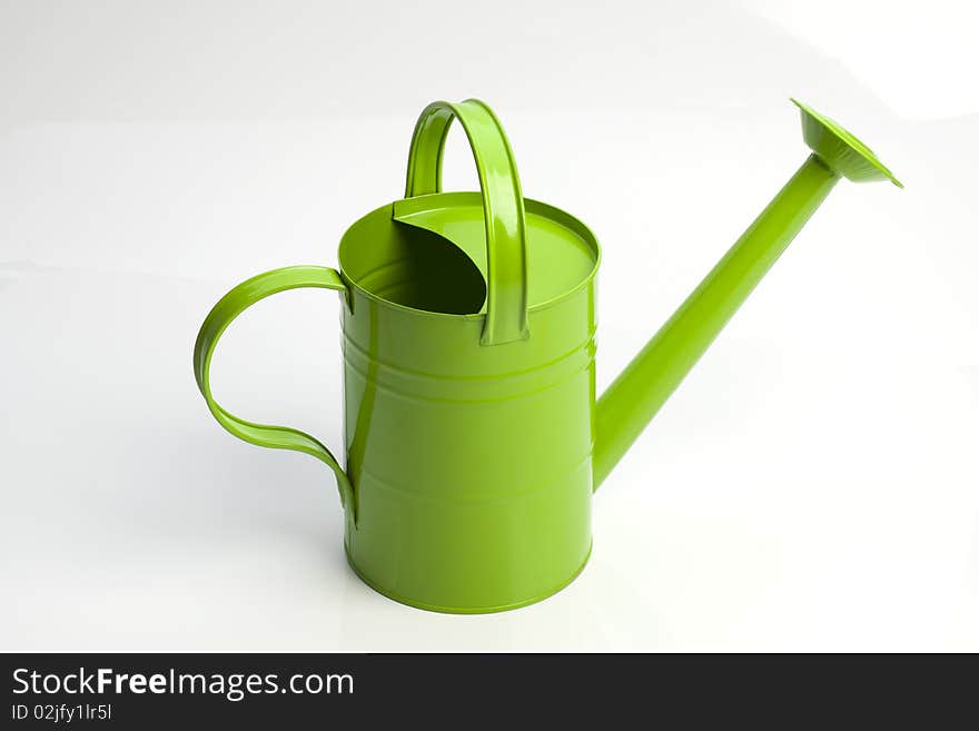 Green watering can on white background