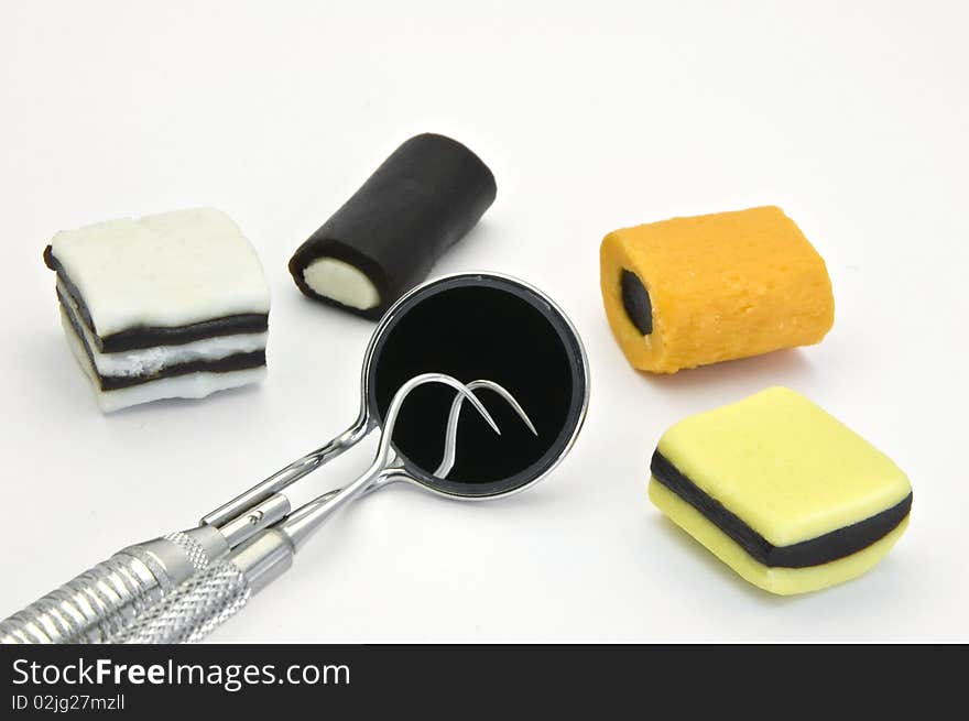 Colored  candies and dental tools on a white background