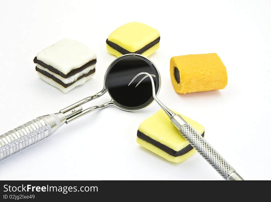 Colored candies and dental tools on a white background