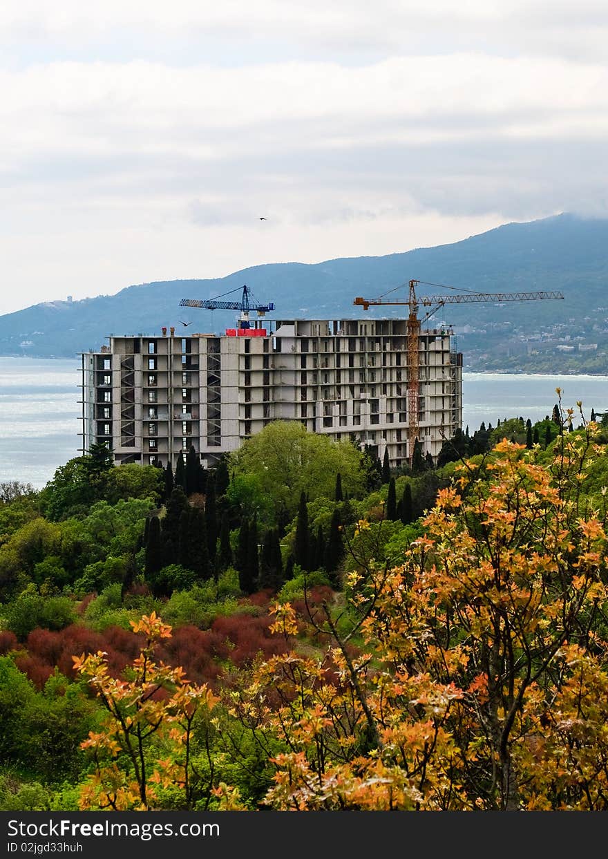 Seaside construction site with yellow buiding crane