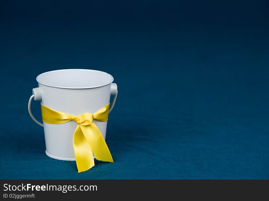 Small white bucket on a blue background. Small white bucket on a blue background