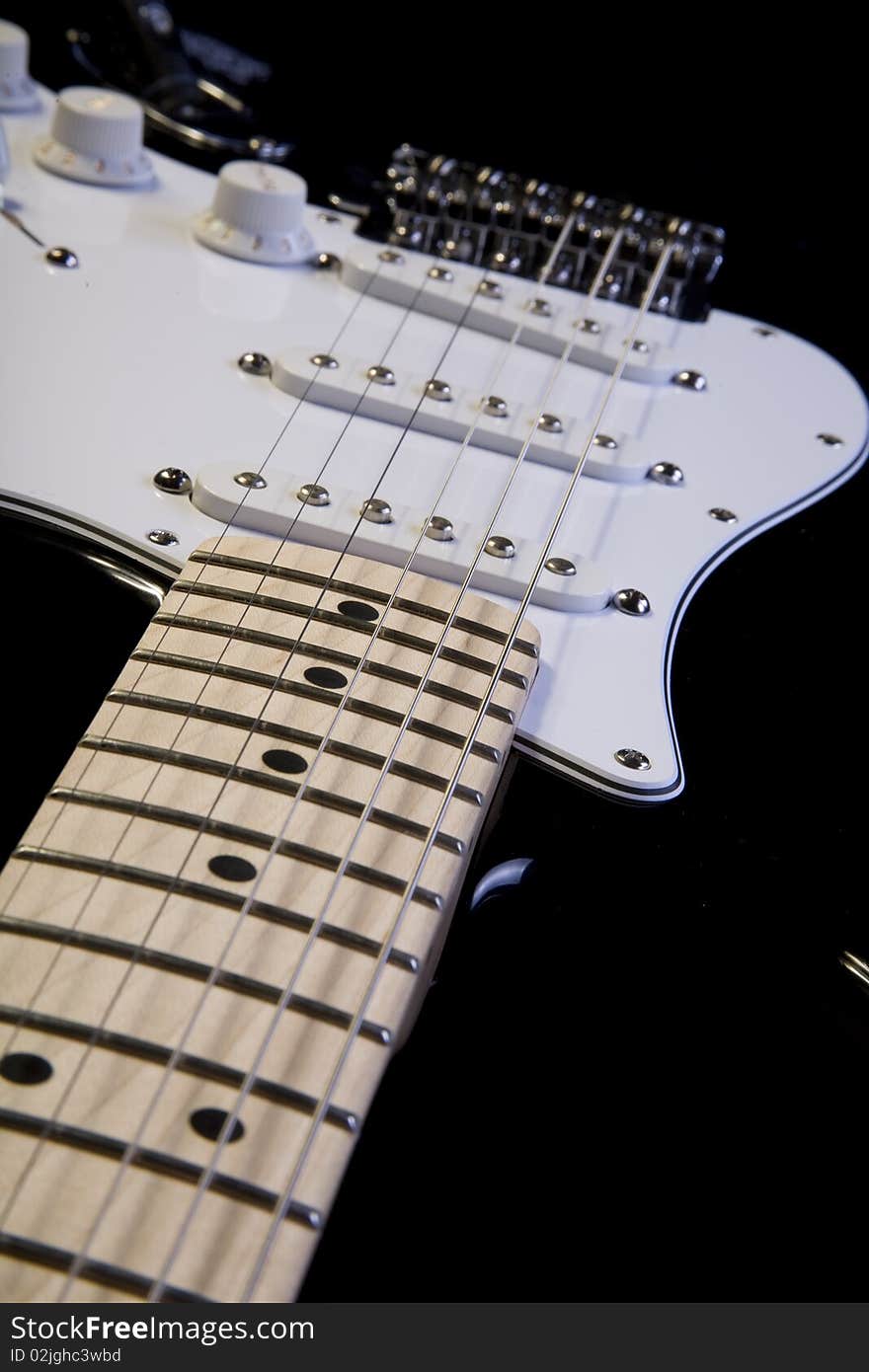 Close-up of a shiny black and white electric guitar legend with clear wood. Close-up of a shiny black and white electric guitar legend with clear wood