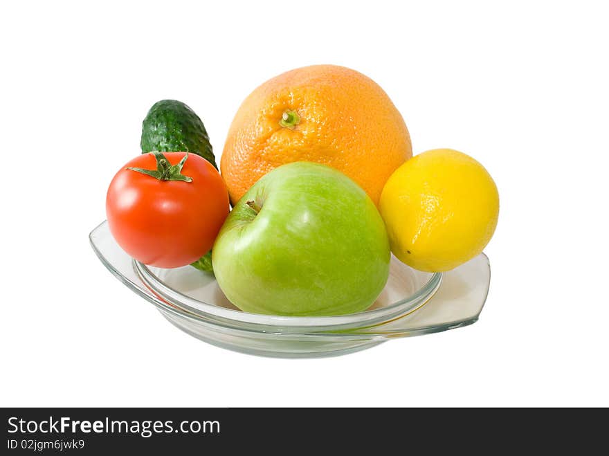 Fruits and vegetables on plate isolated on white background