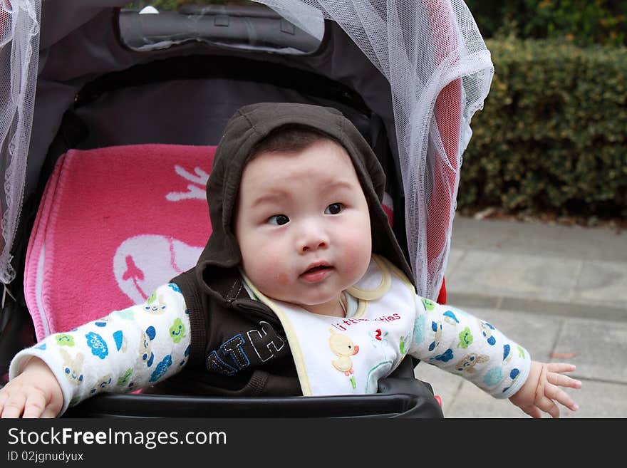 Lovely Chinese baby is sitting in the stroller