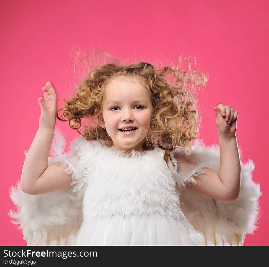 Beautiful little angel girl isolated on pink background