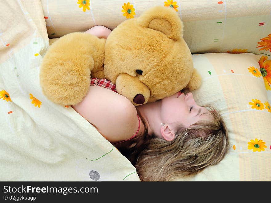 Young girl asleep in her bed with a teddy bear. Young girl asleep in her bed with a teddy bear