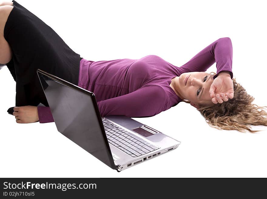 A woman is very tired and laying on the ground by her laptop. A woman is very tired and laying on the ground by her laptop.