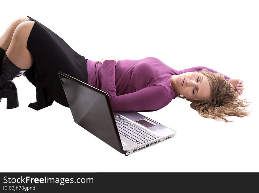 A woman is asleep laying by her lap top computer. A woman is asleep laying by her lap top computer