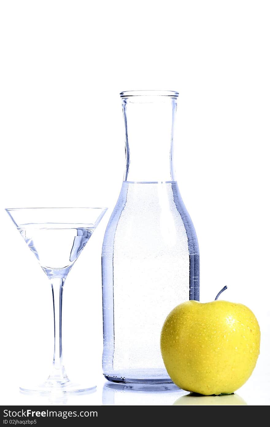 Bottle with transparent water, a glass and apples on a white background