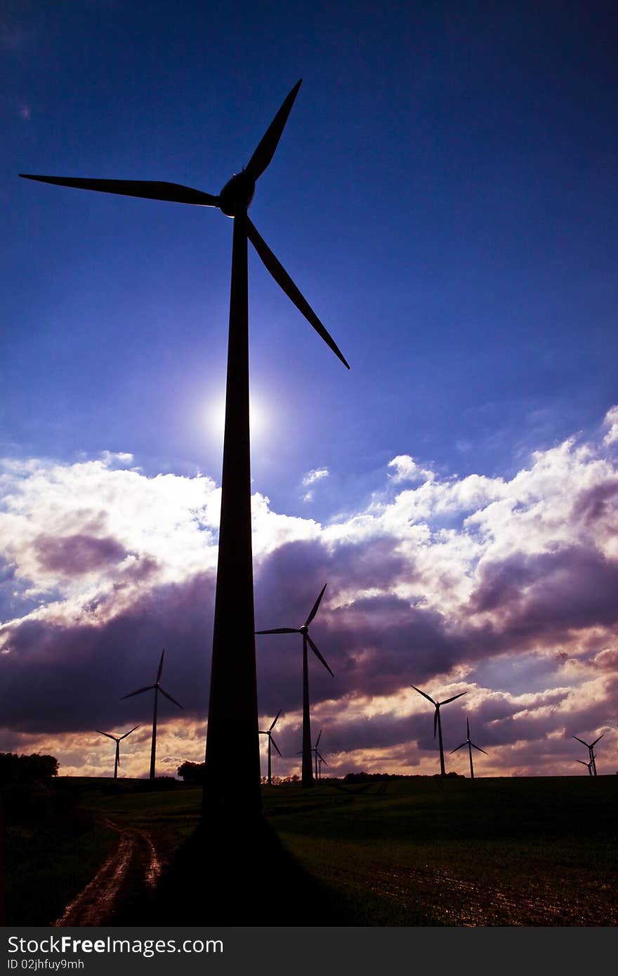 Windmills against a dark, cloudy sky, alternative energy source. Windmills against a dark, cloudy sky, alternative energy source