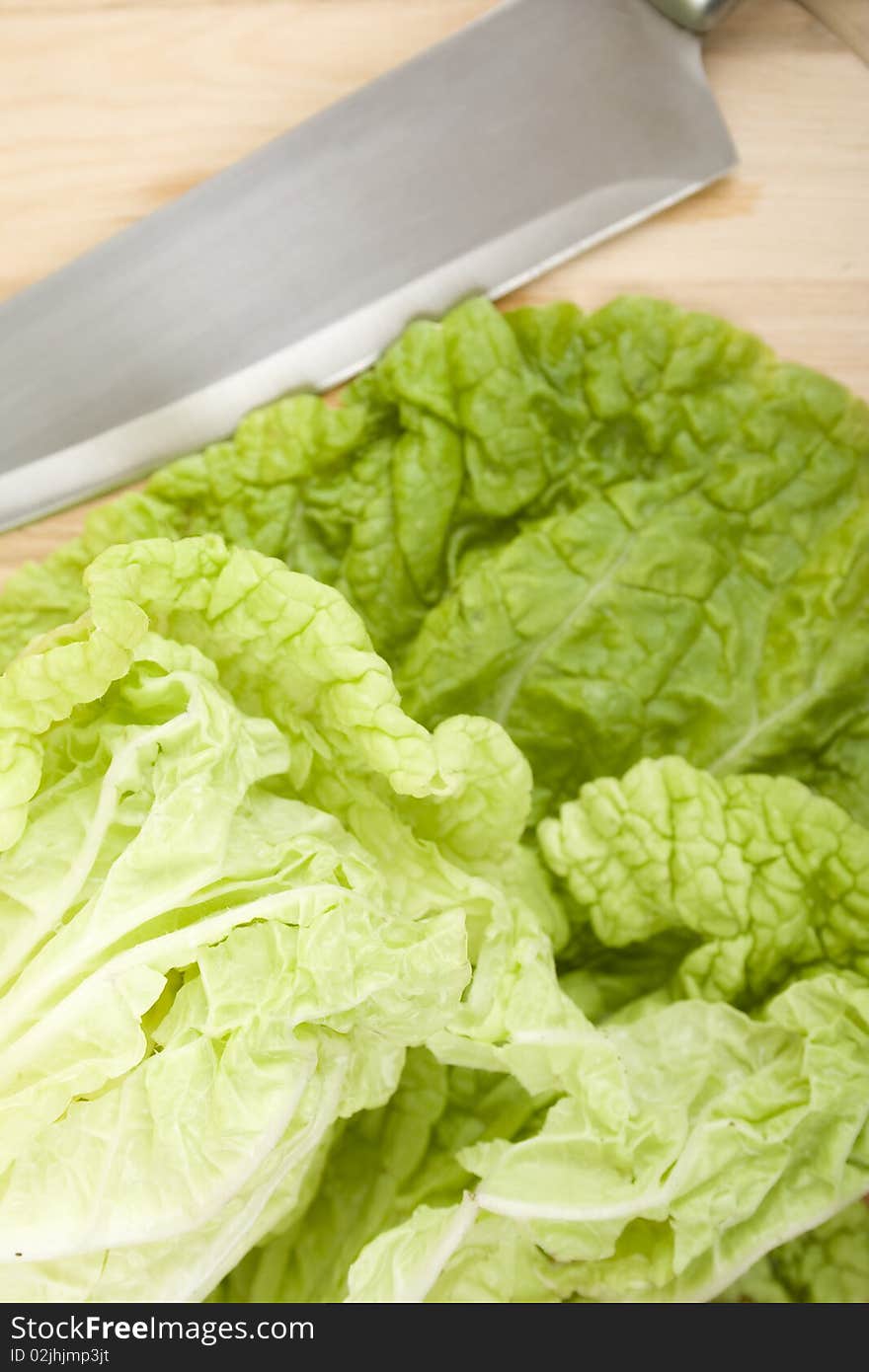 Beijing cabbage lay on a wooden board near a knife