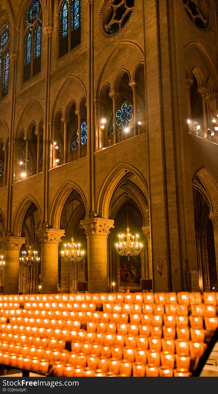 A bank of  glowing prayer candles inside of Notre Dame Cathedral in Paris, France. A bank of  glowing prayer candles inside of Notre Dame Cathedral in Paris, France