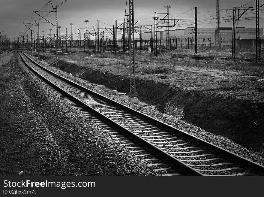 Single railroad track with industrial background