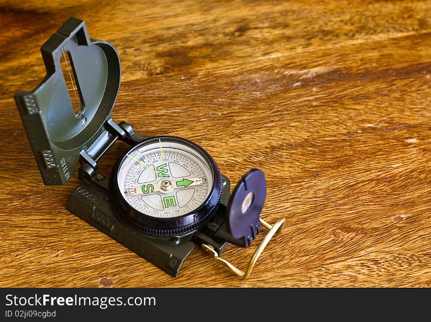 Military compass on wooden table