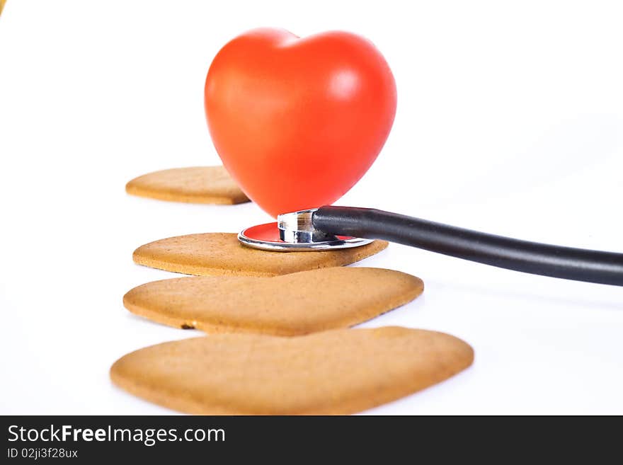 Red hart wits a stethoscope examining brown ginger bred hearts