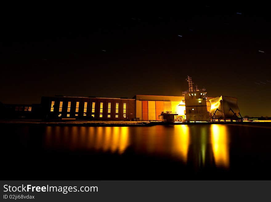 A shipyard at night with deckhouse on the wharf