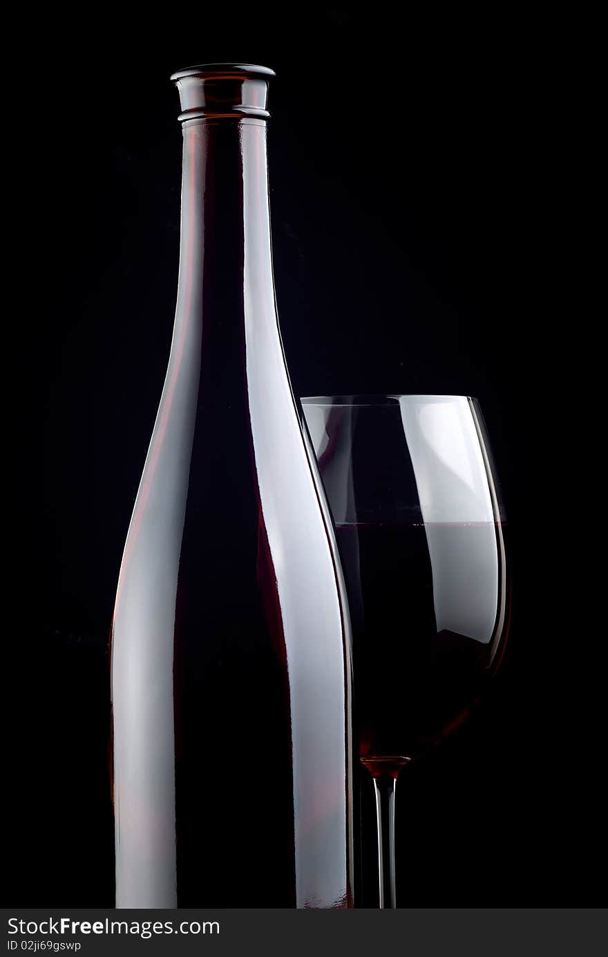 Bottle and glass on a black background. Bottle and glass on a black background