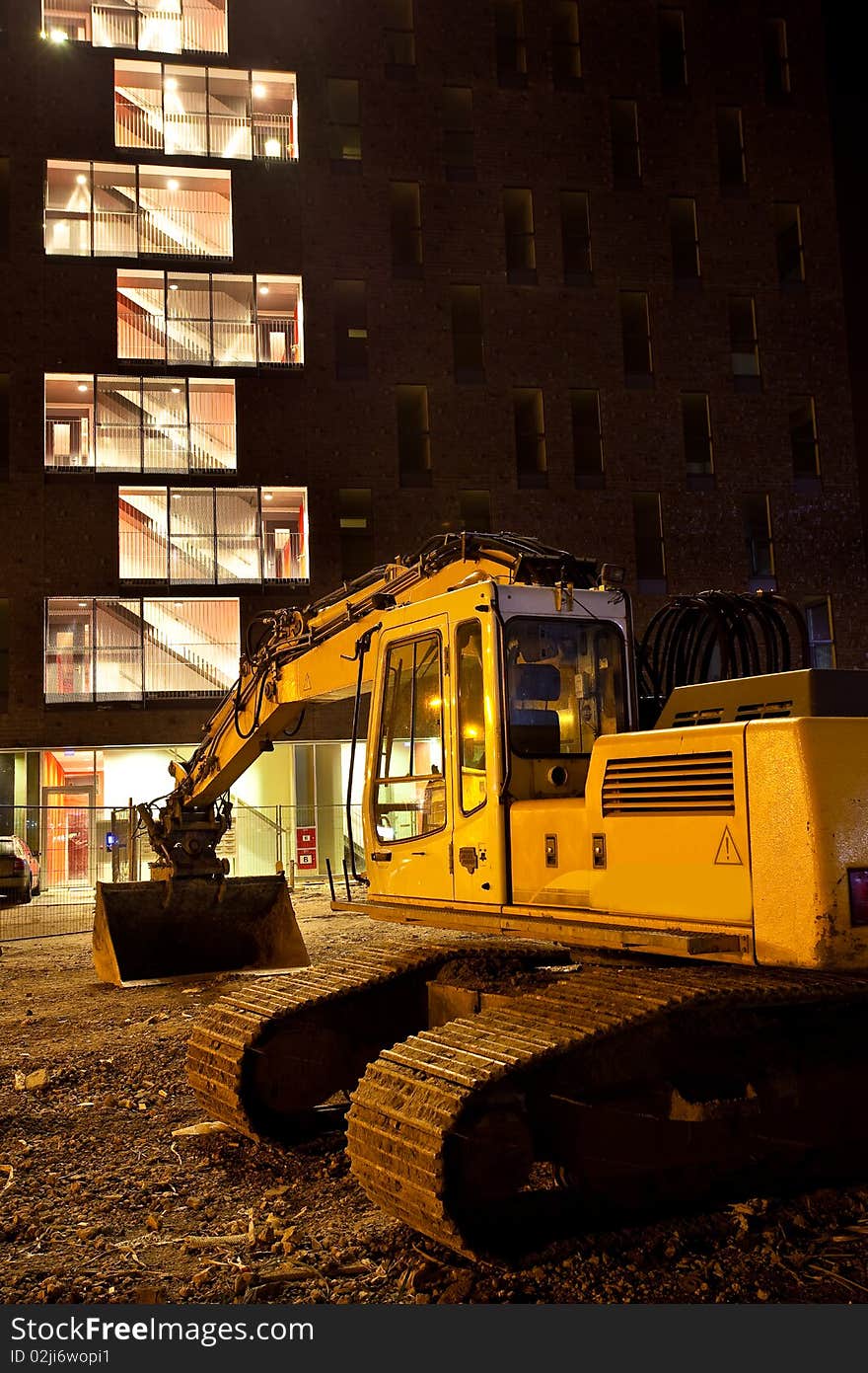 Excavator crane in front of building