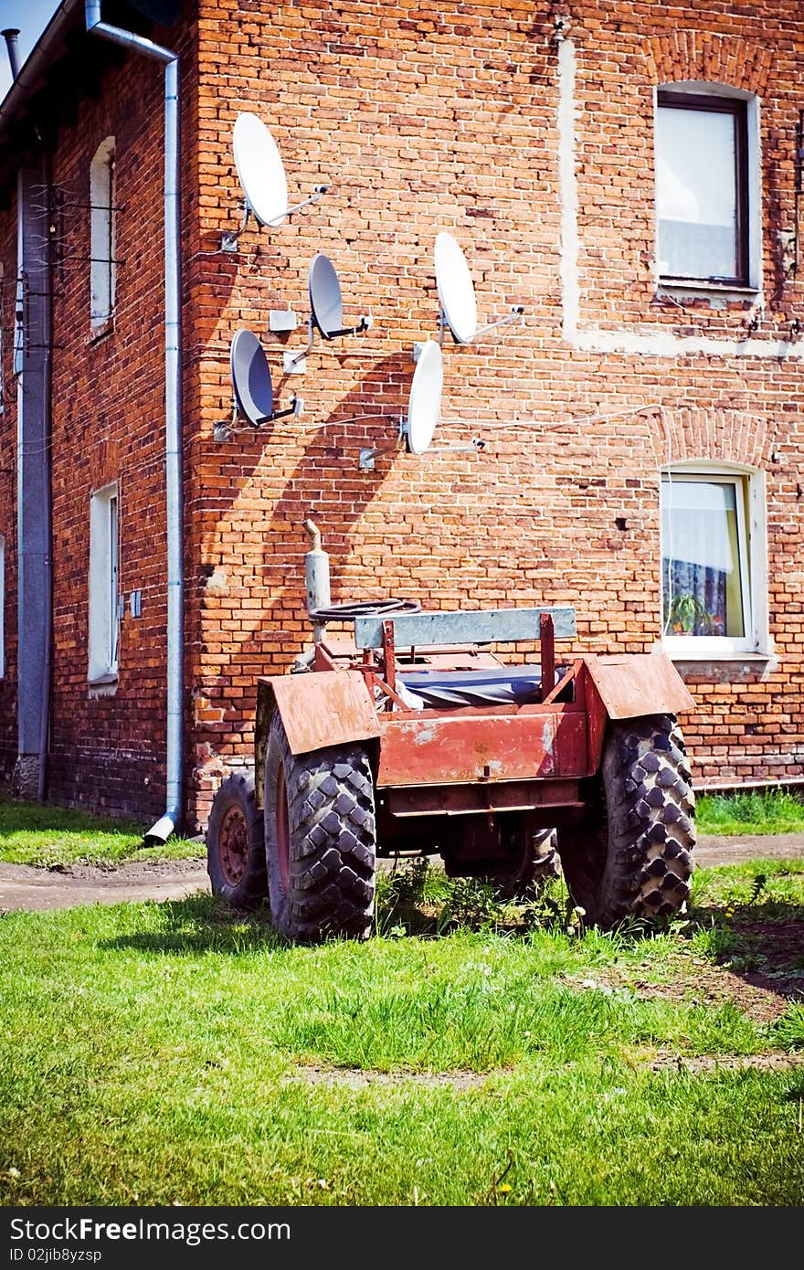 Satellite antennas and tractor in village. Satellite antennas and tractor in village