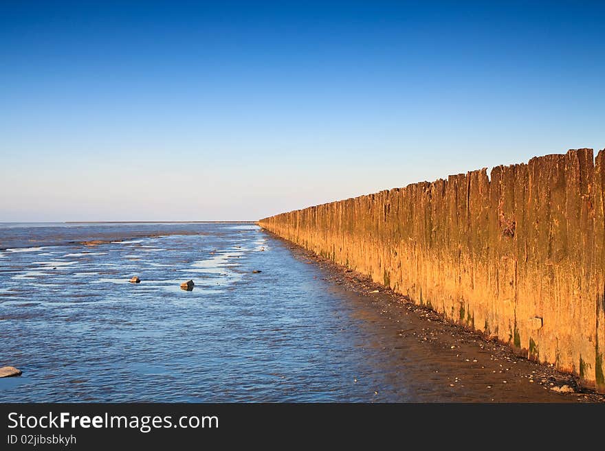 Poles in the ocean at sunset