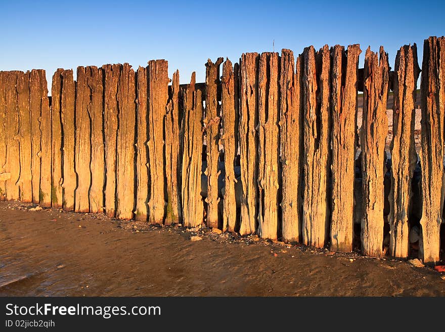 Poles in the ocean at sunset