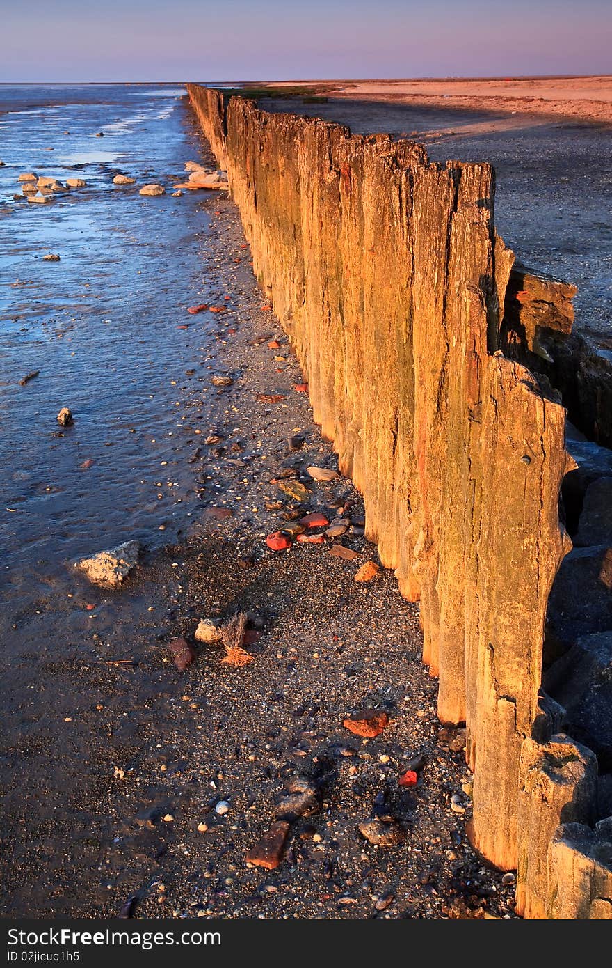 Poles in the ocean at sunset