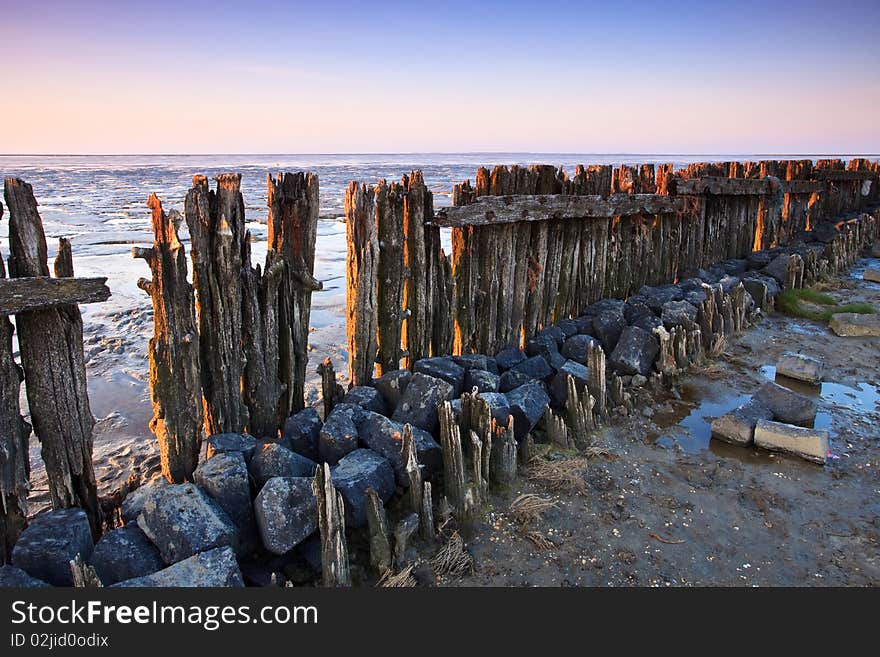 Poles in the ocean at sunset