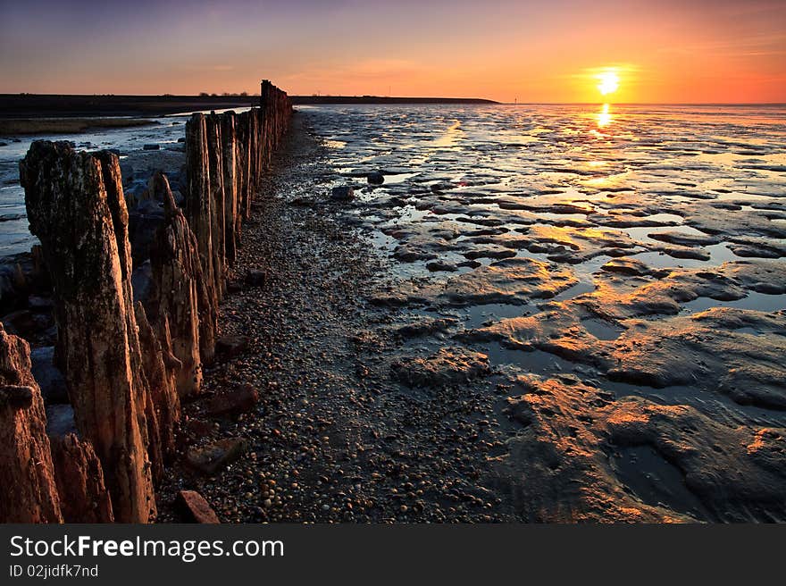 Poles in the ocean at sunset