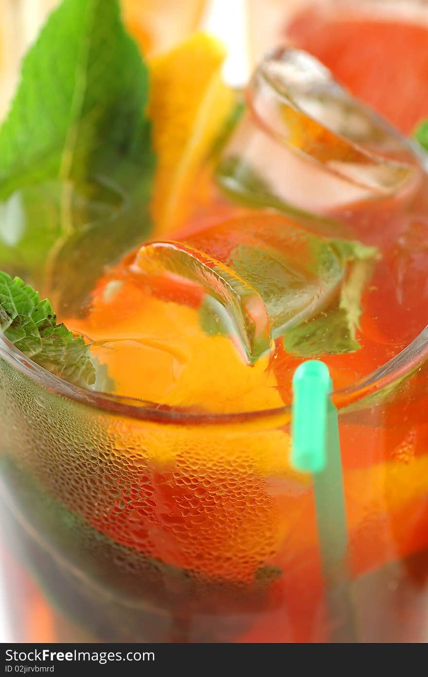 Fresh cocktail with an orange, mint and a grapefruit on a white background