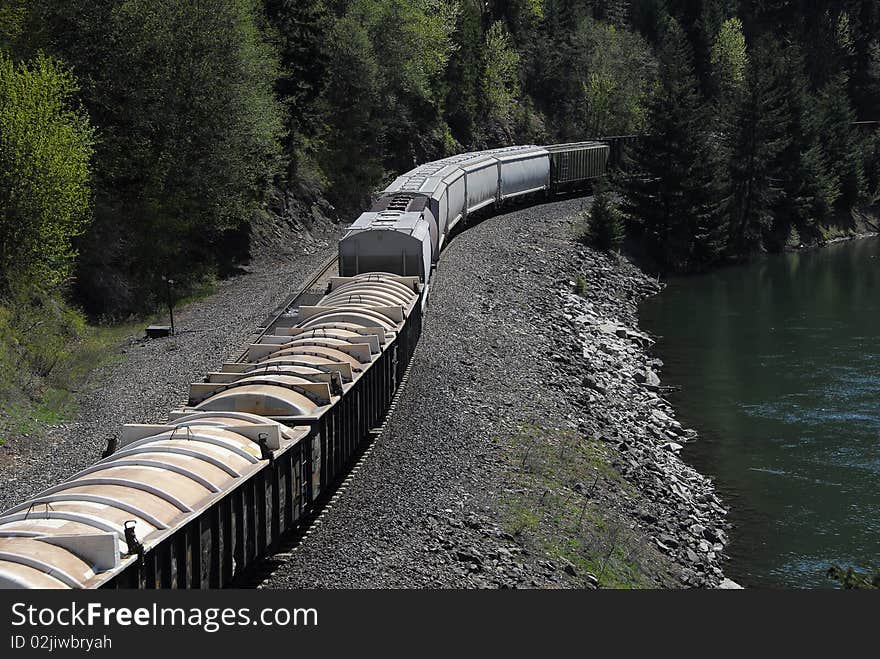 Train on tracks by river in forest