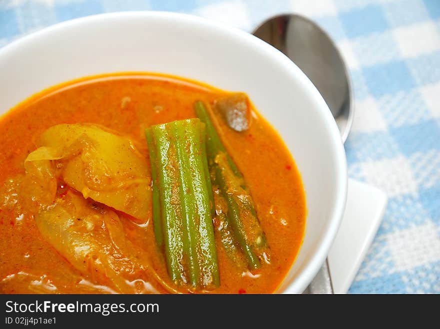 Asian spicy vegetarian curry. Ingredients include potatoes, lady fingers, and tomatoes. Suitable for Asian food culture, healthy lifestyle, and diet and nutrition.