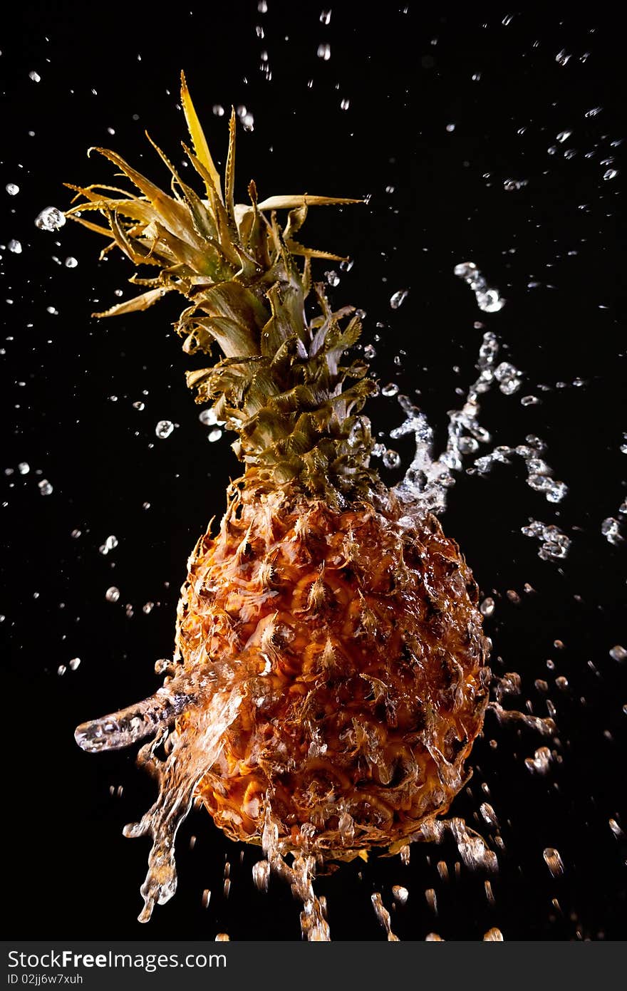 Pineapple on a black background with water drops