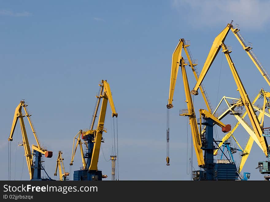 Four big industrial cranes at commercial dock